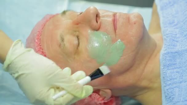 Uma Cosmetologista Feminina Aplica Uma Máscara Lama Rosto Homem Com — Vídeo de Stock