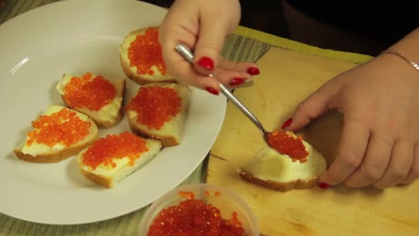 Жінка поширює канапку з маслом і червоною ікрою для шведського столу — стокове відео