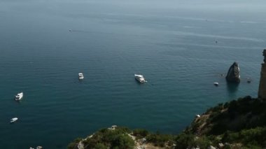 Deniz kaya ile. Kıyı şeridinde yelkenli yatlar. Zaman sukut