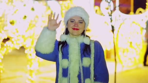 Улыбающаяся снегурочка машет рукой перед сияющими огнями кареты — стоковое видео