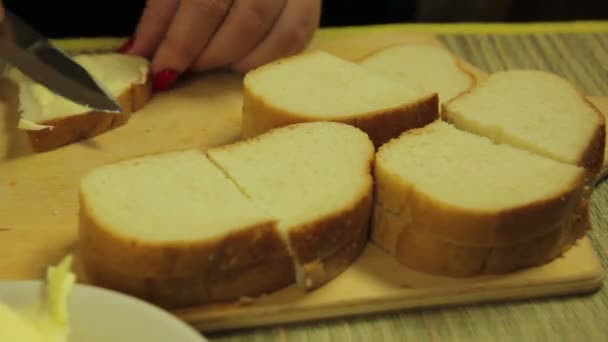 女性の手に広がるカナッペのパンにバターを塗る。時間周 — ストック動画
