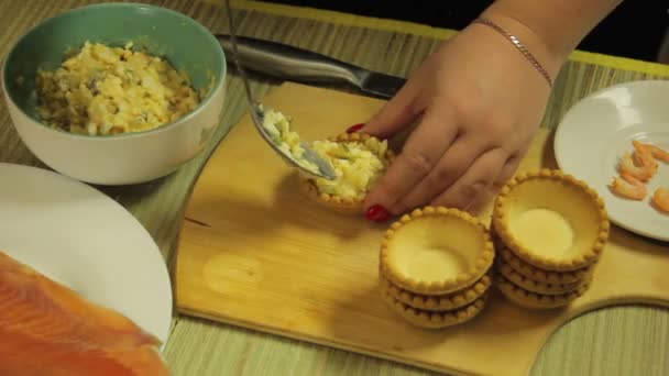 Una mujer pone tartaletas en una ensalada. El plan medio — Vídeos de Stock