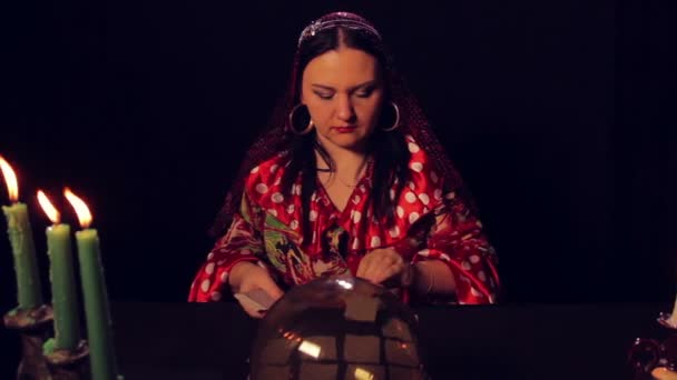 Gypsy waarzegster aan de tafel bij kaarslicht verspreidt fortunetelling kaarten — Stockvideo