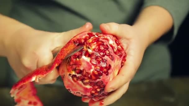 Frau putzt Granatapfelfrucht mit Messer auf weißem Teller auf Holztisch — Stockvideo