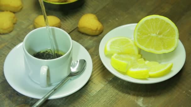 Un getto d'acqua bollente viene versato in una tazza di tè nero — Video Stock