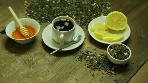 Taza de té, soldadura, miel y limón en una mesa de madera — Vídeos de Stock