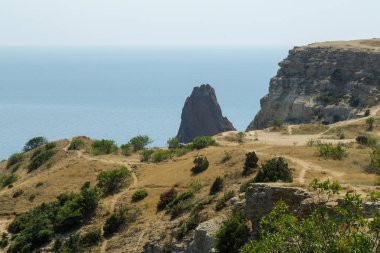 Puslu bir sis denizde yüksek dağlar görüntülemek.