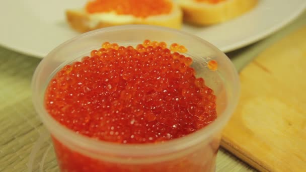 Un frasco de caviar rojo y una cuchara con caviar encima. Primer plano — Vídeo de stock