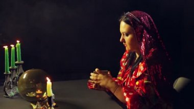 Mum ışığında bir servet salon genç bir çingene kehanet için kartları karıştırır. Ortalama planı
