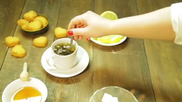 女性がカップにスプーンで入れたての緑茶をミックスします。 — ストック動画