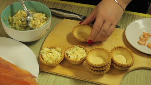 En kvinna sätter tartlets på en sallad. Den genomsnittliga planen — Stockvideo