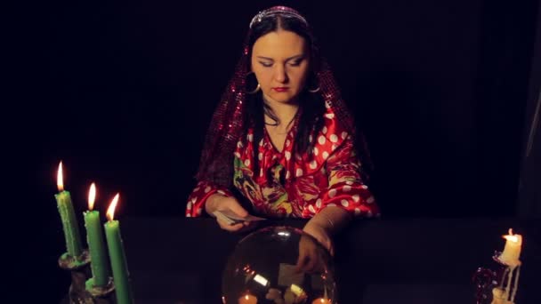 Cikánská věštkyně u stolu při svíčkách se diví karty — Stock video