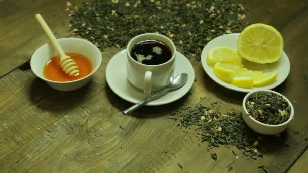 Taza de té, soldadura, miel y limón en una mesa de madera — Vídeos de Stock