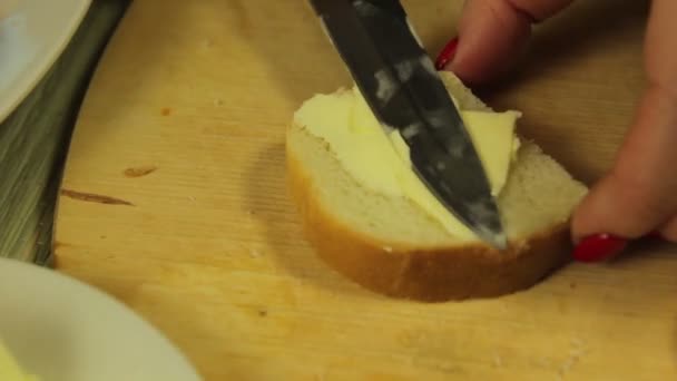 La mano femenina unta mantequilla blanca para canapés con mantequilla — Vídeo de stock