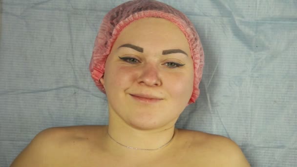 O rosto de uma mulher sorridente deitada em um sofá médico — Vídeo de Stock