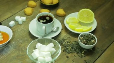 Fincan çay, kaynak, bal ve limon ahşap bir masa üzerinde