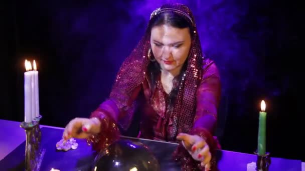 В волшебном салоне при свечах цыганка читает будущее в зеркальном шаре . — стоковое видео