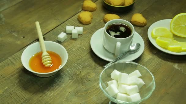 Kopp te, svetsning, honung och citron på ett träbord — Stockvideo
