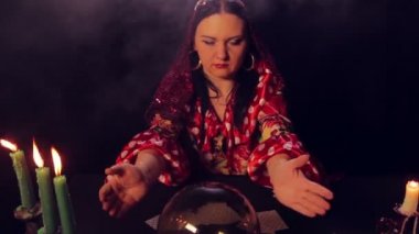 Sihirli bir kristal gelecekte çingene falcı mum ışığında masada okur