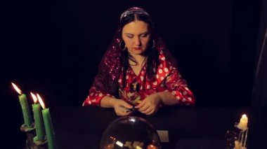 Çingene falcı mum ışığında masada kartları merak ediyor..