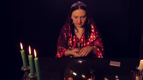 Цыганский гадалка за столом при свечах чудеса на картах — стоковое видео