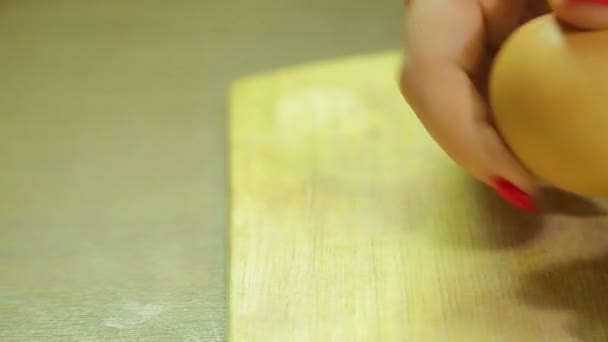 Woman cleans boiled egg on wooden board. Close-up — Stock Video