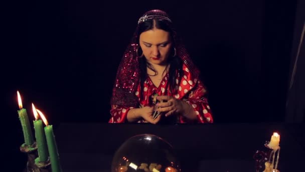 Gypsy fortunę bankomat przy stole przy świecach zastanawia się karty — Wideo stockowe