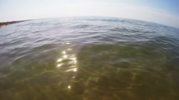 Agua de mar con fondo arenoso al sol — Vídeo de stock