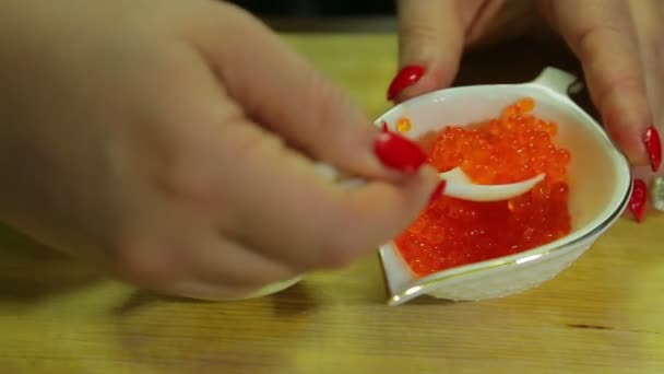 一个女人在煮鸡蛋的一半上勺子吃红色鱼子酱 — 图库视频影像