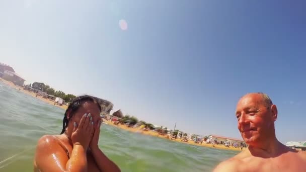 Happy man and woman in the sea near the coast — Stock Video