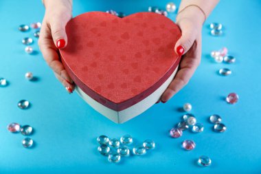 Bir kızın elinde bir kalp şeklinde aşıkların günü için bir hediye ile kutu.