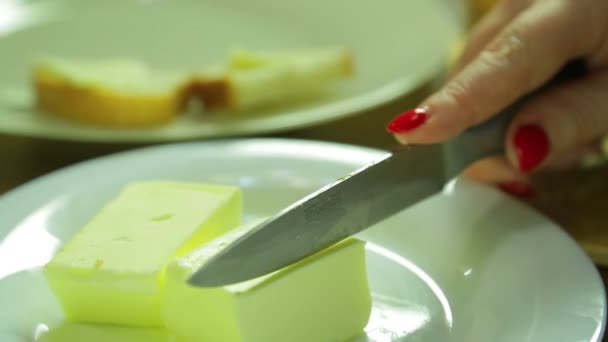Vrouw afsnijdt, een stukje boter voor canap s. Close-up — Stockvideo
