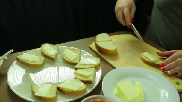 Женщина режет масло на хлеб для канапе икрой — стоковое видео