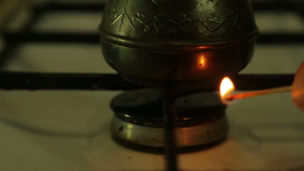 Чоловік запалює газовий пальник на газовій кухонній плиті з сірником. Крупним планом — стокове відео