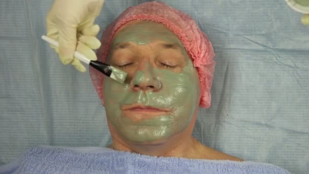 Una Cosmetóloga Guantes Está Aplicando Una Máscara Barro Cara Cliente — Vídeos de Stock