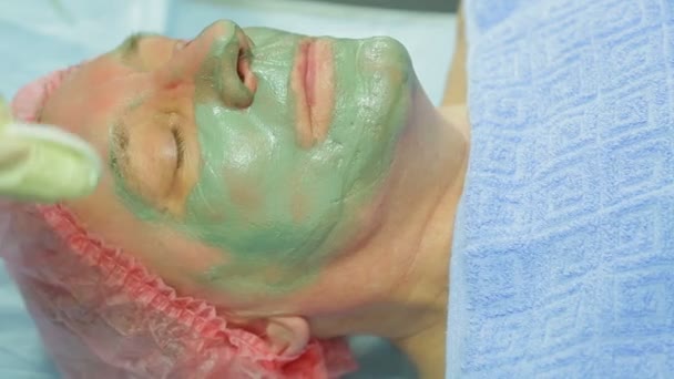 Seorang Kosmetolog Perempuan Menghilangkan Masker Lumpur Terapeutik Dari Wajah Seorang — Stok Video