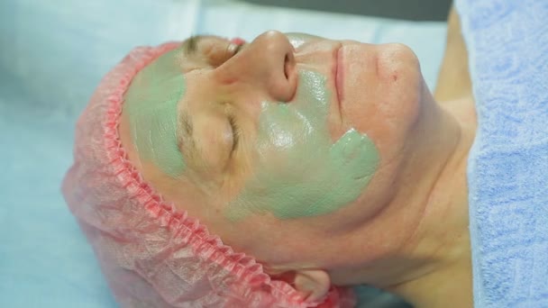 Cosmetologist Fêmea Nas Luvas Aplica Uma Máscara Terapêutica Barro Cara — Vídeo de Stock
