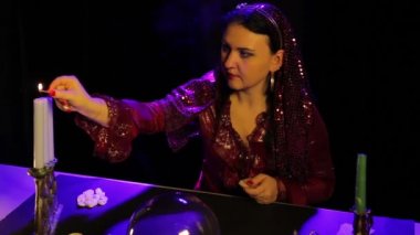 Kehanet salonunda masada bir çingene bir kırmızı elbise ışıklar mum oyma bir şamdan