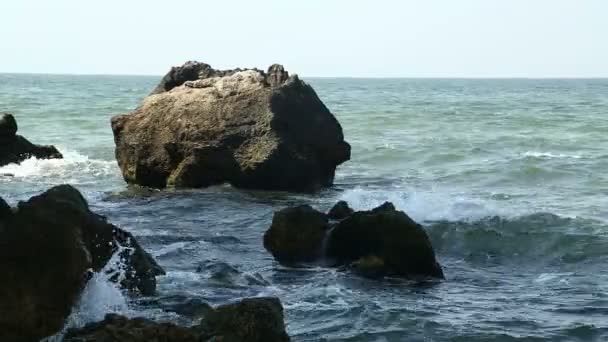 Olas marinas chocando contra rocas costeras y rocas a la sombra — Vídeo de stock