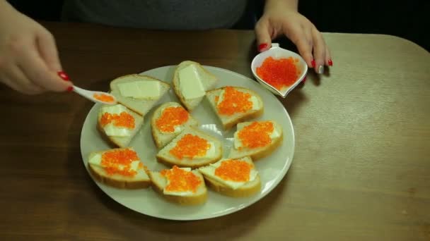 女性は、Iornitsa のスプーンからキャビアを受け取り、バター、カナッペにバターを広がる — ストック動画
