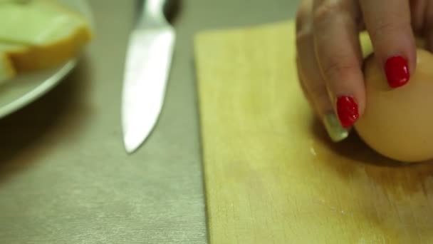 Жіночі руки очищають яйце від мушлі — стокове відео