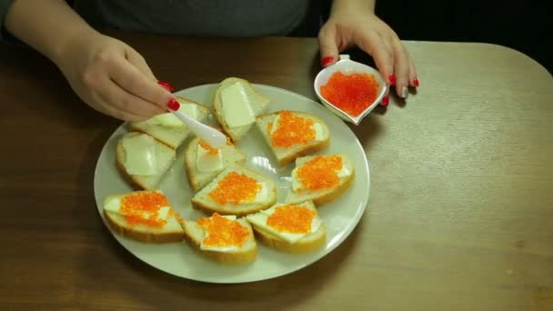 Жінка приймає червоною ікрою у громадських Iornitsa і поширює масла на за Канапе з маслом — стокове відео