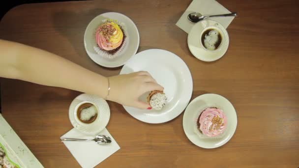 Main féminine met dans une plaque blanche gâteaux pour le café — Video