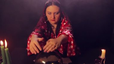 Sihirli bir kristal gelecekte çingene falcı mum ışığında masada okur