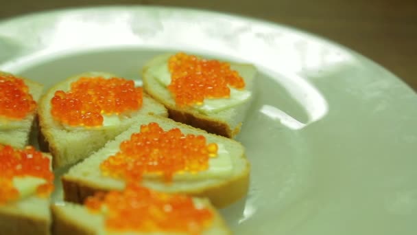 Vit tallrik med kanapéer med röd kaviar — Stockvideo