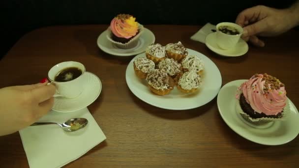 El hombre y la mujer en la mesa están bebiendo café de tazas blancas — Vídeos de Stock