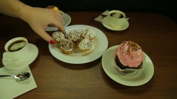 La mano femenina pone las tortas en el plato blanco al café — Vídeos de Stock