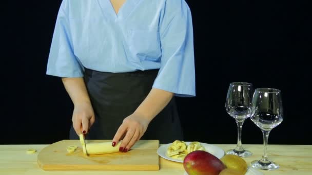 Frau kocht auf schwarzem Hintergrund Scheiben Verbot auf einem Holzbrett — Stockvideo