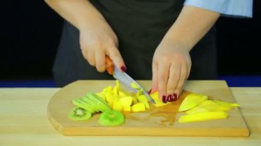 Eller ahşap bir gemide kivi ve mango parçalar koparıp