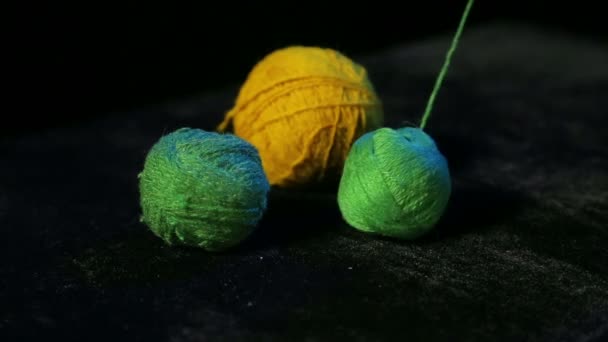 Unwinding of a green skein of knitting yarn on a black background — Stock Video